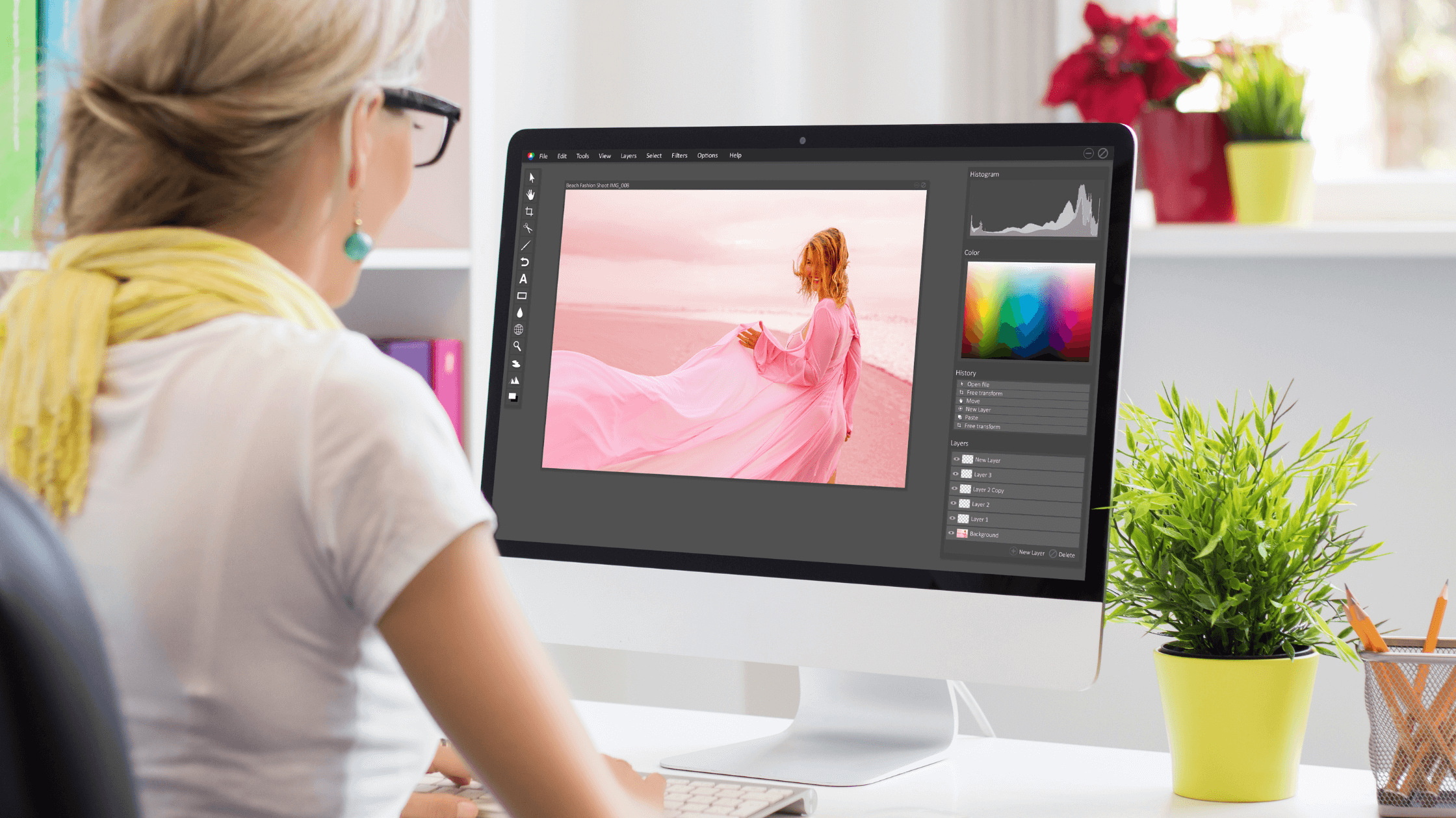 A graphic designer or digital media student, editing an image on a computer, demonstrating the hands-on skills learned in a graphic design career and creative trades.
