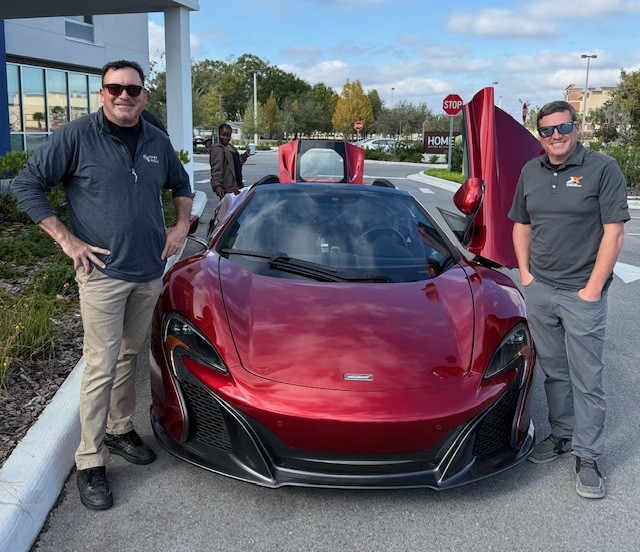 Vince and Joey beside a McLaren