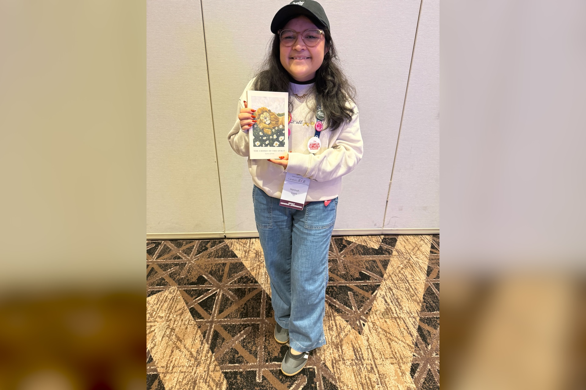 UI design career inspiration — Hannah, a user interface designer and published poet, holding her book The Chord of the Spirit