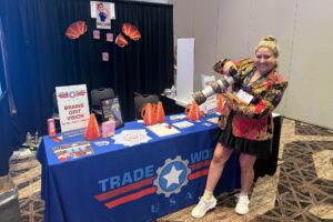 Film production career inspiration — Silvana with her camera and telephoto lens at the Trade Works USA event booth