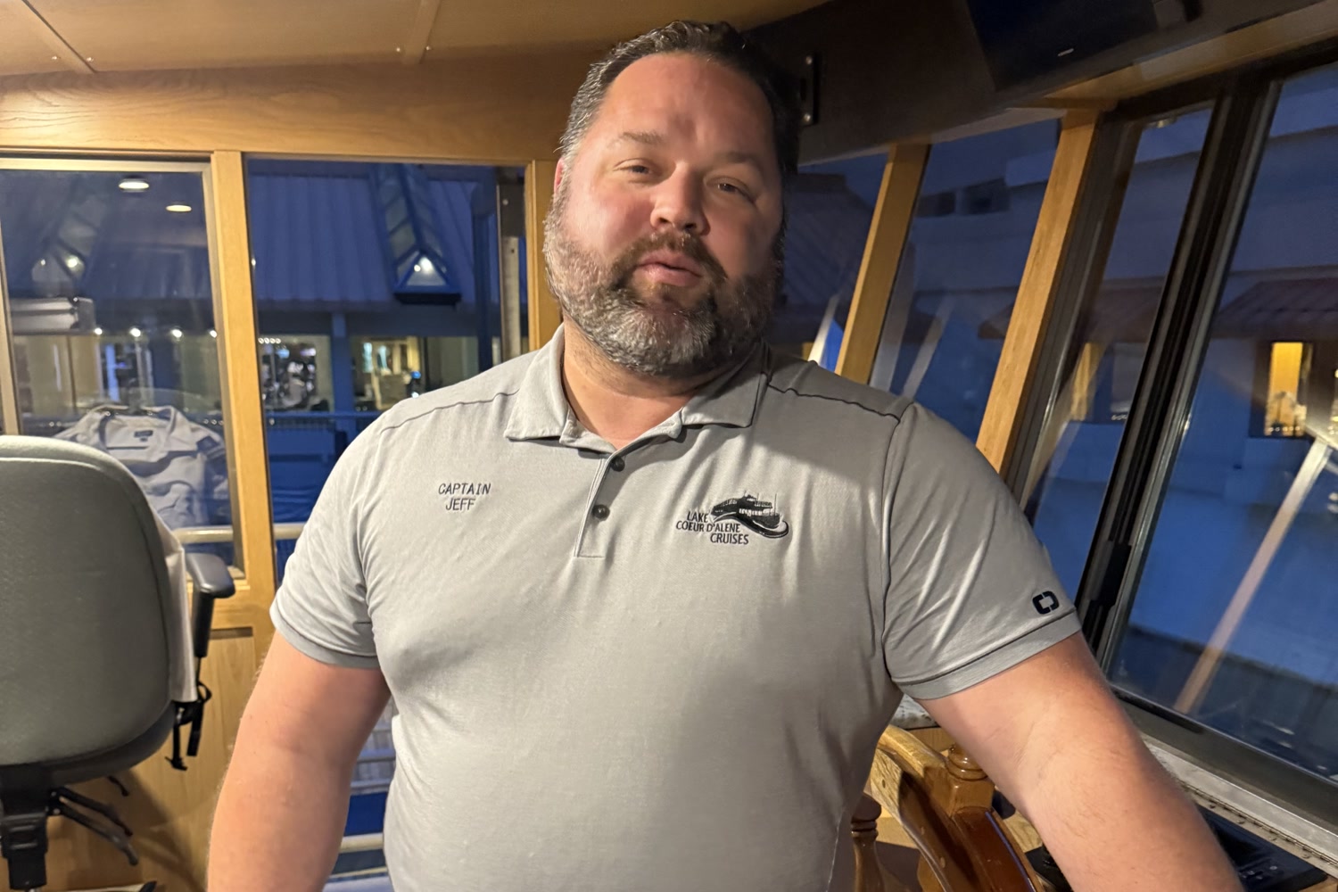 Captain Jeff at the wooden ship's wheel in the wheelhouse of the Lake Coeur d'Alene Cruises dinner boat